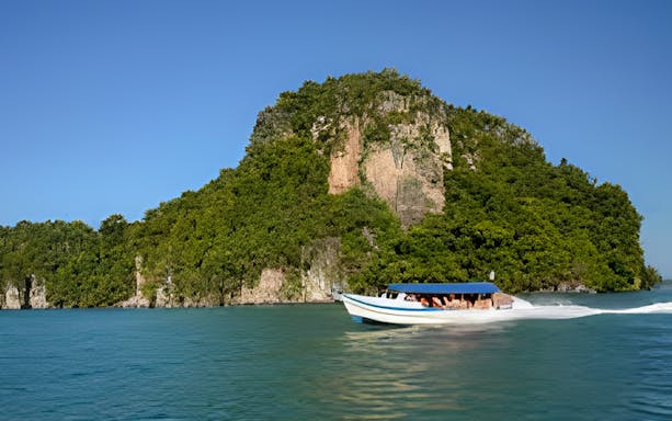 Boat cruising near lush island on Langkawi Day Cruise with Lunch.