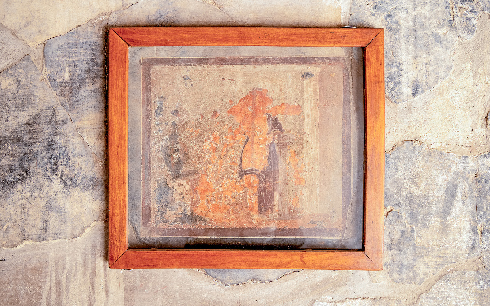 Framed ancient fresco with faded colors on a wall in Herculaneum, Italy.