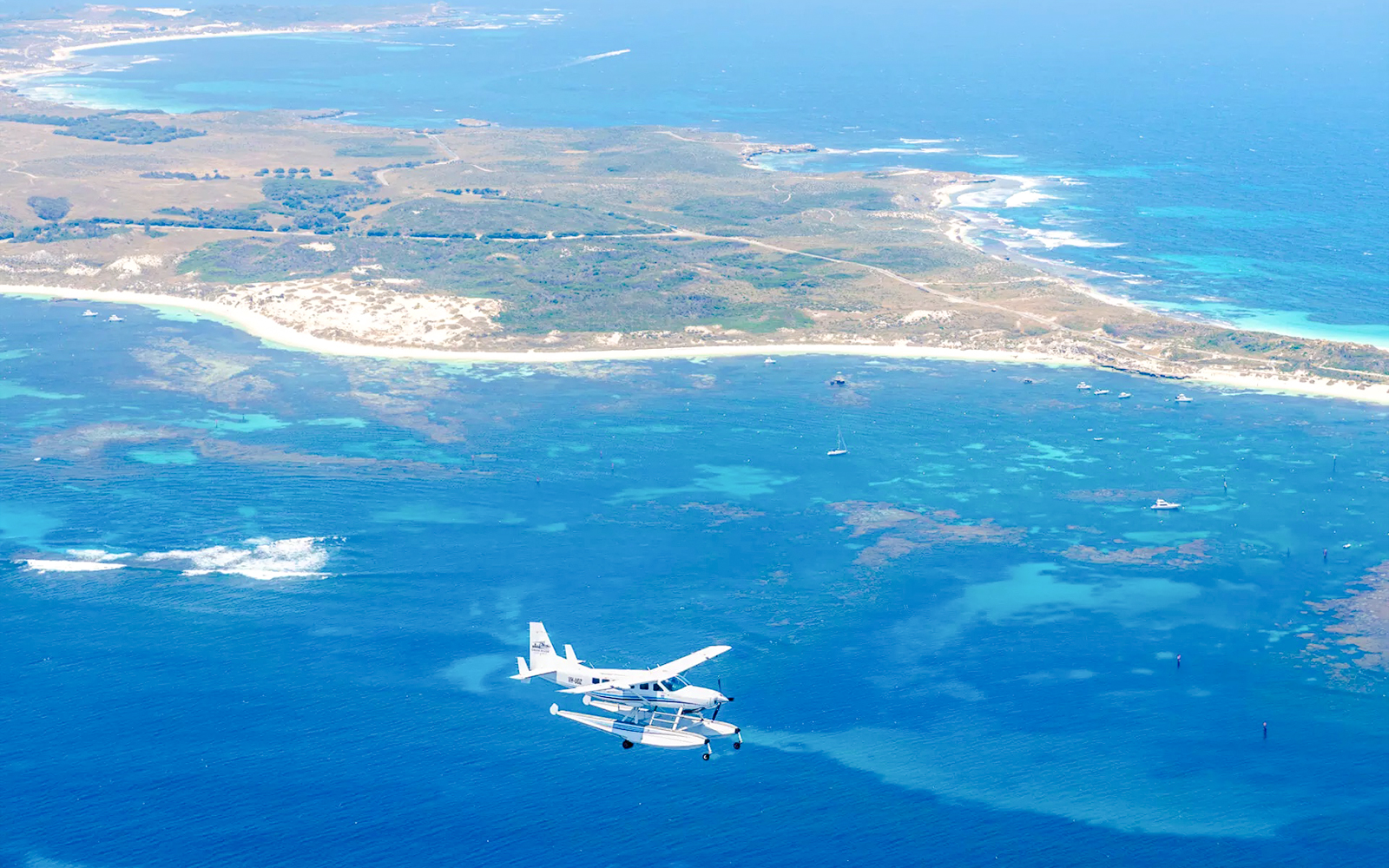 Seaplane flying over turquoise waters near Rottnest Island, Australia.