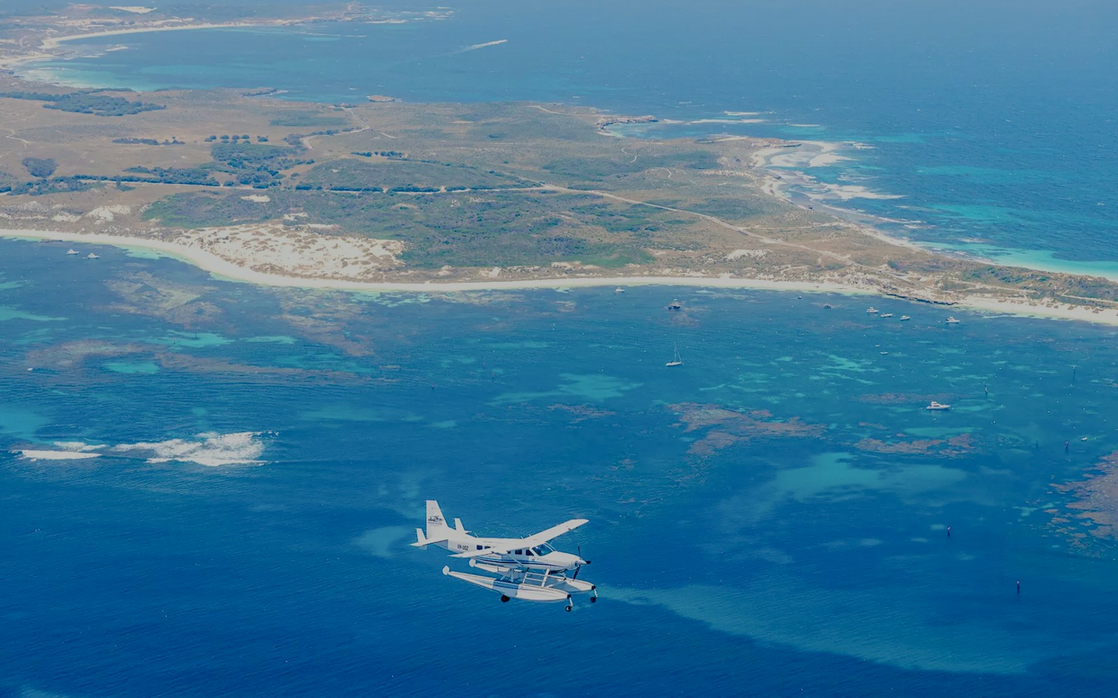 Seaplane flying over turquoise waters near Rottnest Island, Australia.