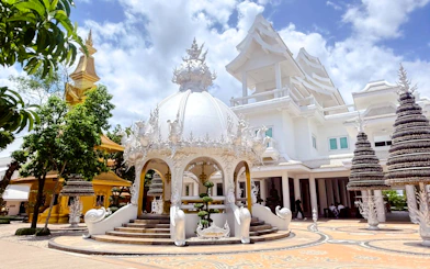 White temple pavilion with intricate carvings in Chiang Rai, part of Chiang Mai to Chiang Rai tour.