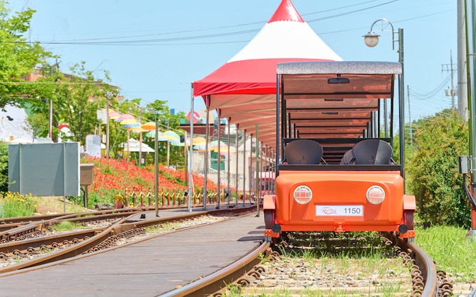 Orange Gangchon Rail Bike on tracks near station, South Korea.