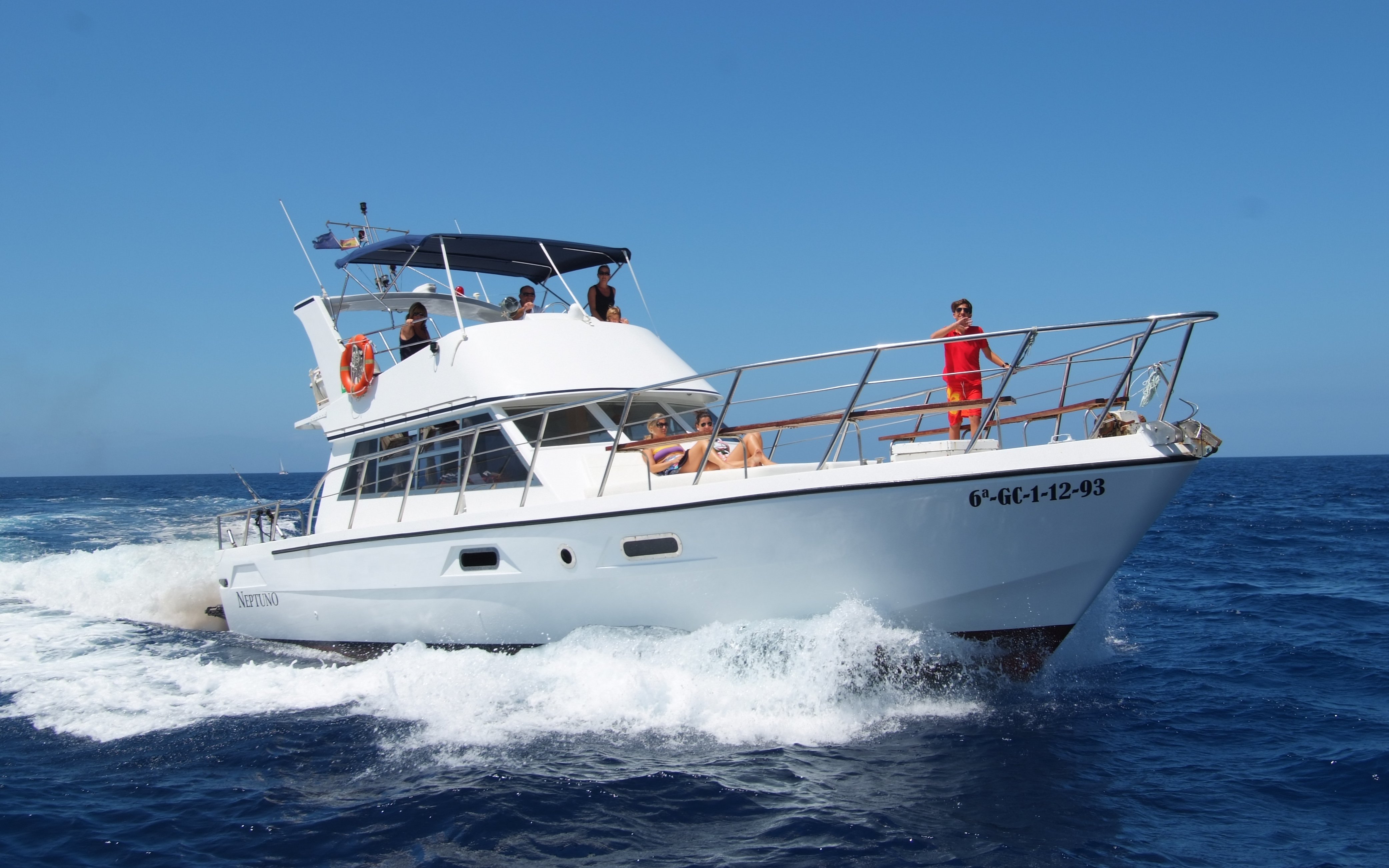 Tourists relaxing on a yacht during whale and dolphin watching in Tenerife.