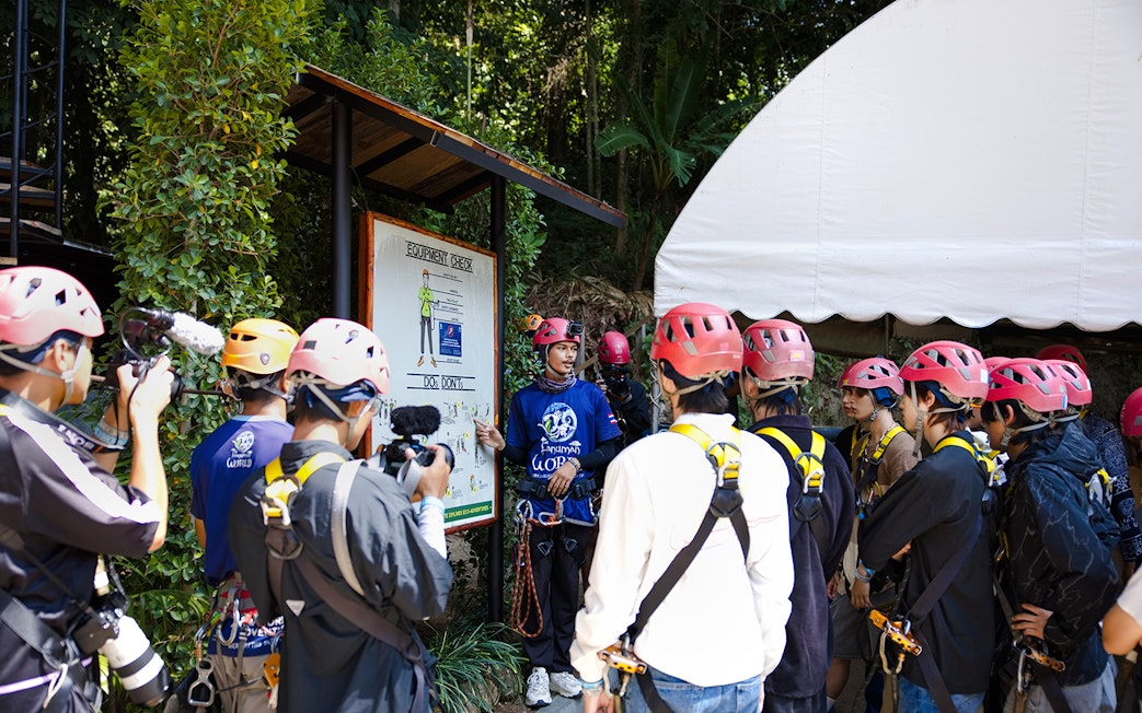 Safety briefing at Hanuman World with group wearing helmets and harnesses.