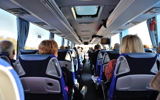Passengers seated on a bus traveling from Toulouse to Carcassonne Castle, France.