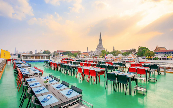 Riverside dining setup on a cruise with Wat Arun view in Bangkok.