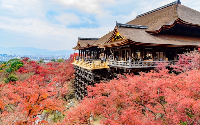 Kiyomizu Temple in Kyoto with autumn foliage and city view.
