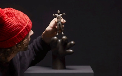 Hand holding a small sculpture by Frankey at Moco Amsterdam's Planet Positive Disruption exhibit.