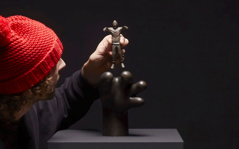 Hand holding a small sculpture by Frankey at Moco Amsterdam's Planet Positive Disruption exhibit.