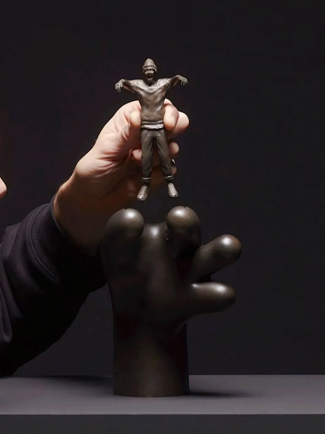 Hand holding a small sculpture by Frankey at Moco Amsterdam's Planet Positive Disruption exhibit.