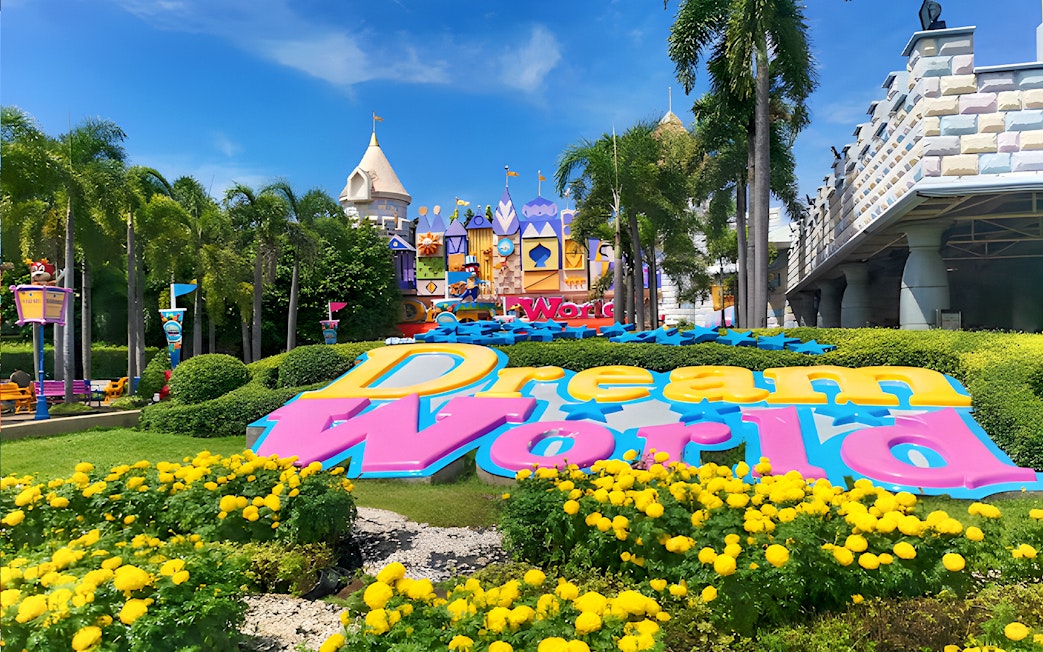 Dream World Bangkok entrance with colorful sign and vibrant gardens.