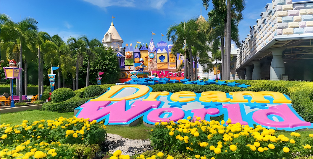 Dream World Bangkok amusement park entrance with colorful castle and visitors.