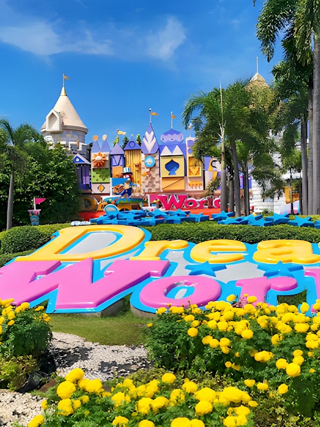 Dream World Bangkok entrance with colorful sign and vibrant gardens.