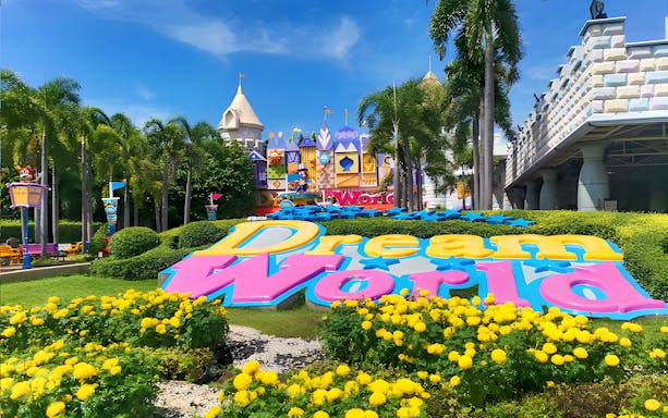 Dream World Bangkok entrance with colorful sign and vibrant gardens.