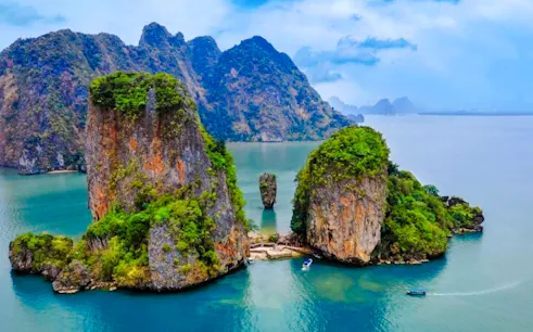 James Bond Island limestone cliffs and speedboat in Phang Nga Bay, Krabi.