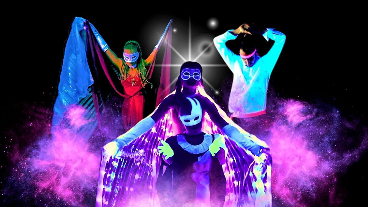 Artists performing in vibrant black light theatre, Prague.