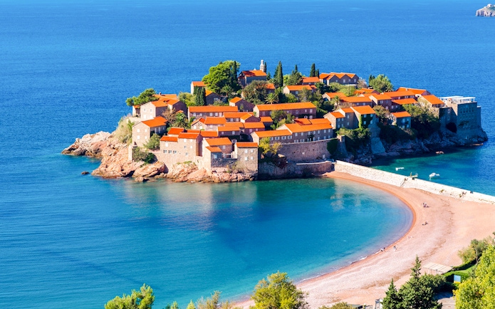 St. Stefan island with historic buildings and beach, Montenegro.