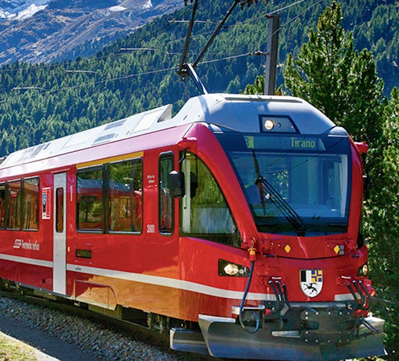 Red train traveling through Swiss Alps on Grindelwald to Jungfraujoch route.