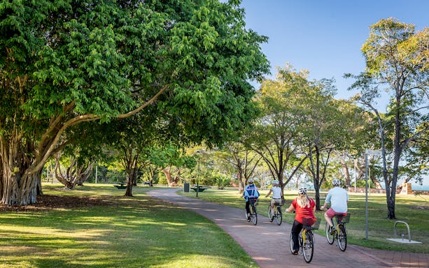 Cyclists on a scenic path during a guided half-day city tour of Darwin.