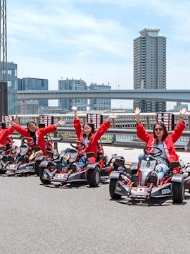 Go-karting group in Tokyo with city skyline in the background.