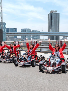 Go-karting group in Tokyo with city skyline in the background.