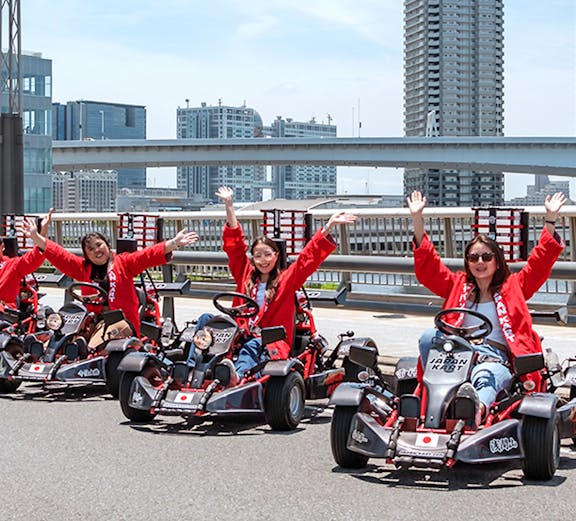 Go-karting group in Tokyo with city skyline in the background.
