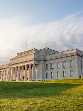 Auckland War Memorial Museum with neoclassical columns and green lawn.