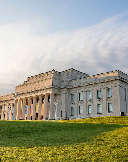 Auckland War Memorial Museum with neoclassical columns and green lawn.