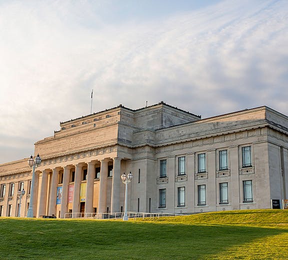 Auckland War Memorial Museum with neoclassical columns and green lawn.