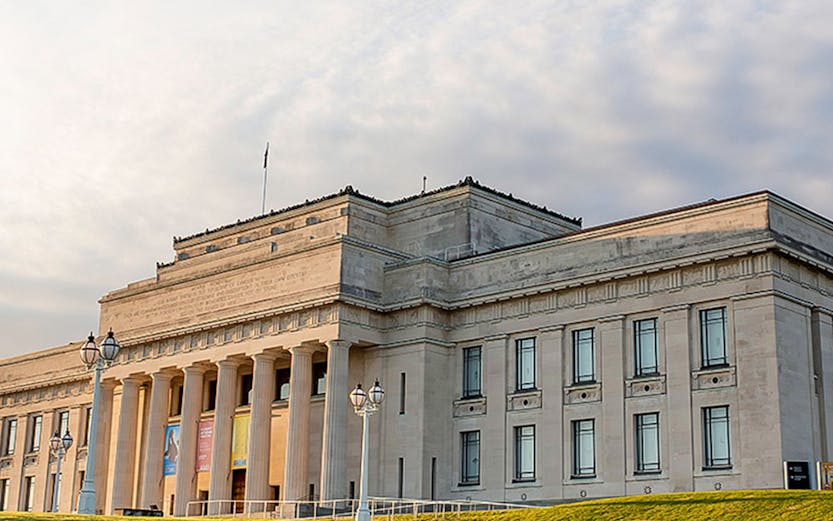 Auckland War Memorial Museum with neoclassical columns and green lawn.