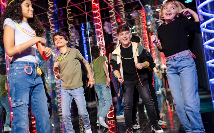 Children enjoying Nickelodeon Universe at American Dream with colorful lights.