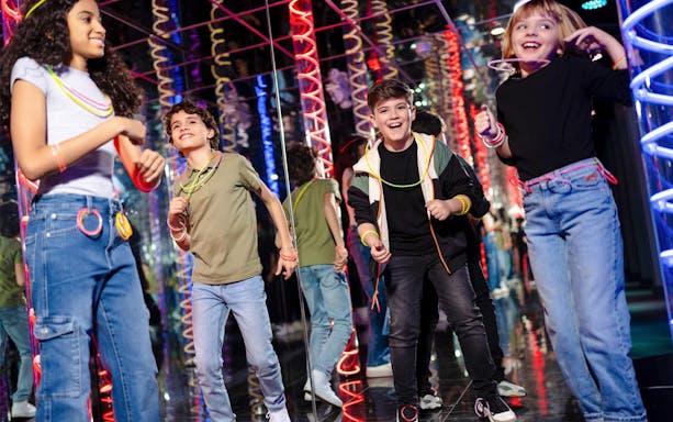 Children enjoying Nickelodeon Universe at American Dream with colorful lights.