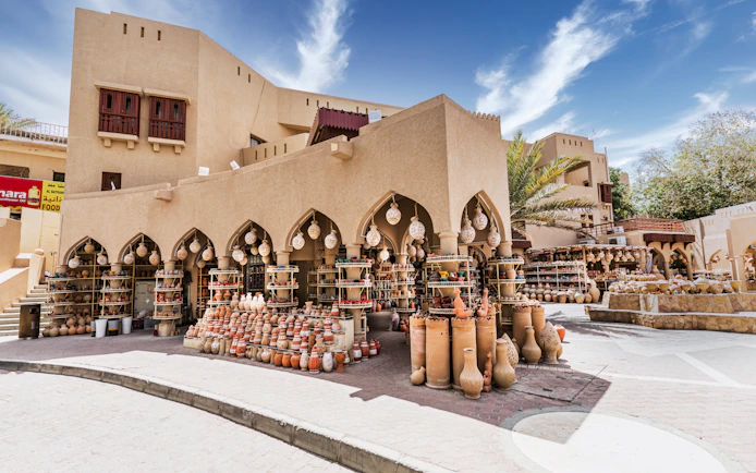 Pottery display at Nizwa Souq, Oman, showcasing traditional clay pots and lanterns.