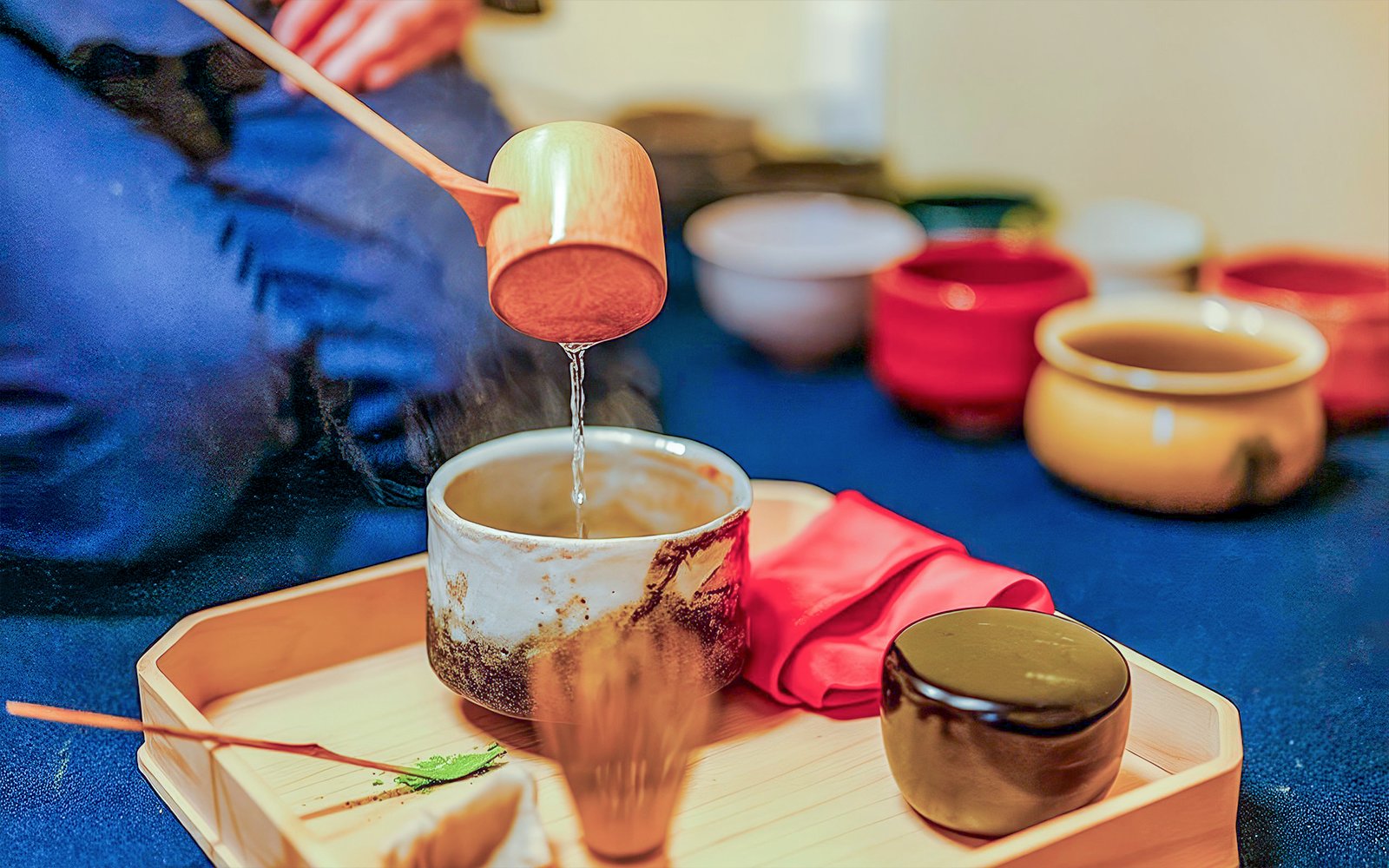 Pouring water into a tea bowl during a private tea ceremony with wagashi in Japan.
