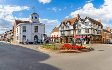 Stratford-upon-Avon town center with historic Tudor-style buildings and a roundabout.