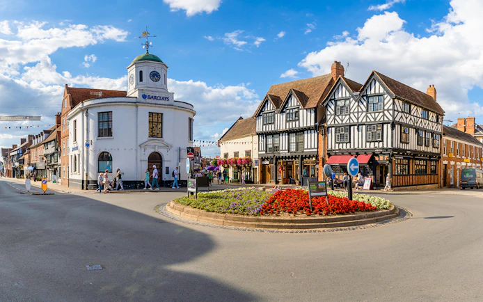 Stratford-upon-Avon town center with historic Tudor-style buildings and a roundabout.