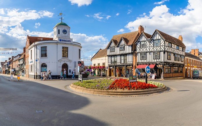 Stratford-upon-Avon town center with historic Tudor-style buildings and a roundabout.