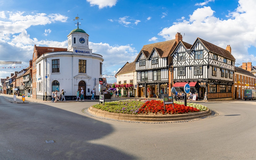 Stratford-upon-Avon town center with historic Tudor-style buildings and a roundabout.