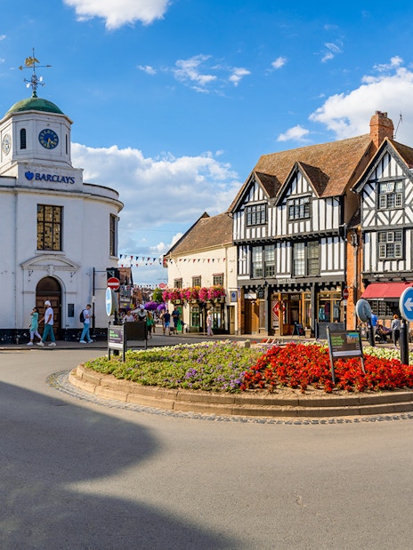 Stratford-upon-Avon town center with historic Tudor-style buildings and a roundabout.