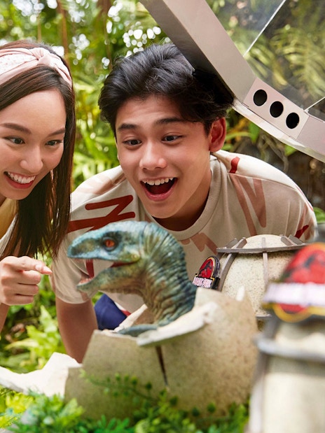 Visitors interacting with a dinosaur hatchling at Jurassic Park Adventure, Universal Studios Singapore.