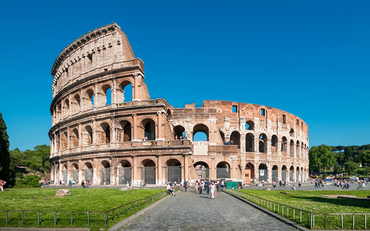 Colosseum in Rome with tourists exploring the ancient amphitheater.