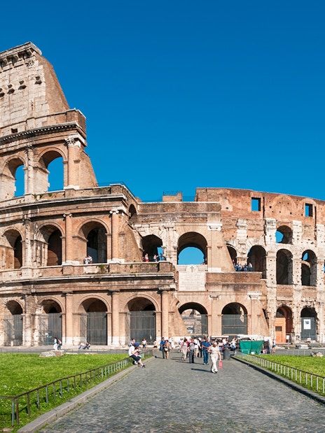 Colosseum in Rome with tourists exploring the ancient amphitheater.