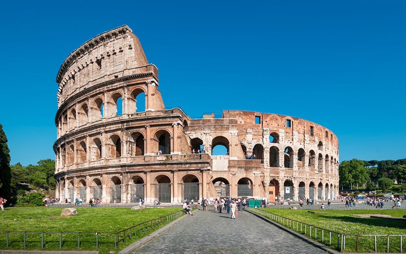 Colosseum in Rome with tourists exploring the ancient amphitheater.