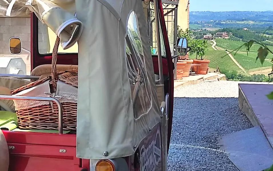 Tuk Tuk with picnic basket overlooking Tuscany vineyards.