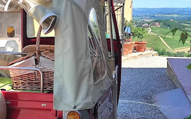Tuk Tuk with picnic basket overlooking Tuscany vineyards.