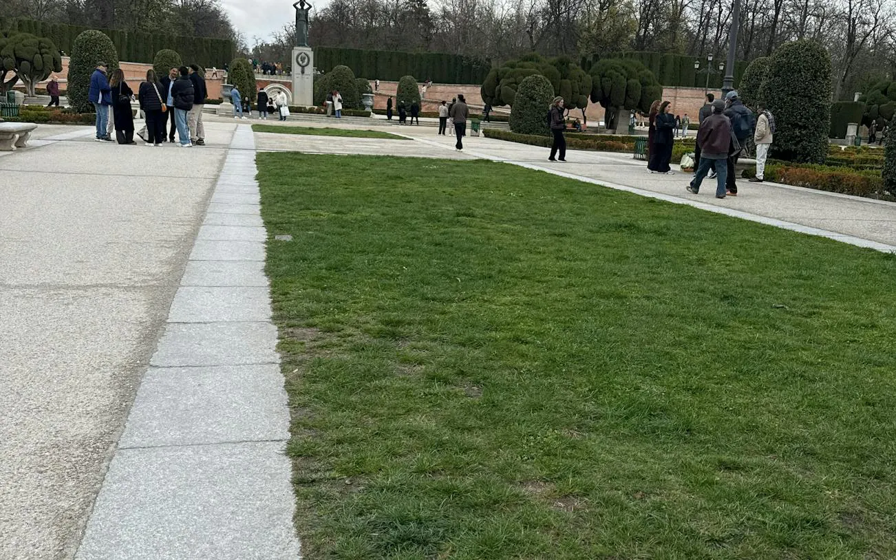 Visitors exploring Retiro Park's landscaped paths in Madrid during a self-guided city game.