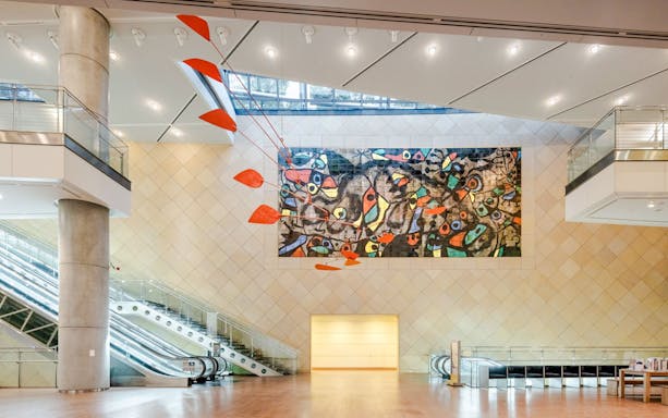 Main hall of The National Museum of Art, Osaka with abstract mural on tiled wall.