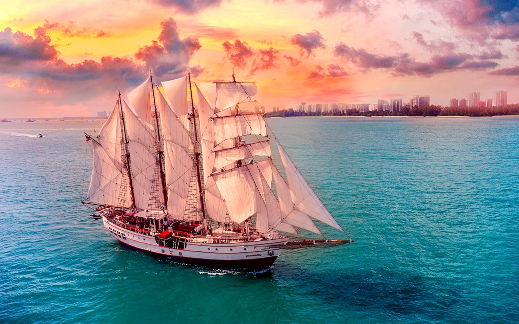 Sailing ship on ocean during sunset, Royal Albatross Dinner Cruise.