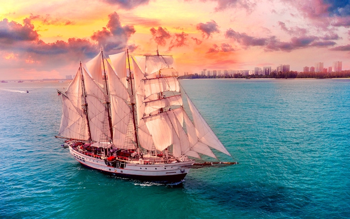 Sailing ship on ocean during sunset, Royal Albatross Dinner Cruise.
