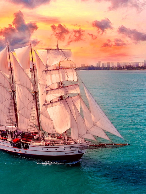 Sailing ship on ocean during sunset, Royal Albatross Dinner Cruise.